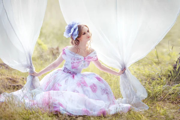 Vrouw met een hoed in de vorm van een bloem op haar hoofd blijft groeien gordijnen — Stockfoto