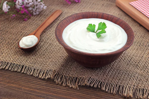ahşap bir masa üzerinde bir kasede ekşi krema