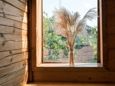 Kır evinin ahşap pencere eşiğinde otlar buketi, rüzgarla savrulan çiçeklerle Idyllic atmosfer