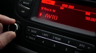 Sürücü kolu sağa çeviriyor ve radyonun sesini yükseltiyor, arabanın sesini kontrol ediyor.