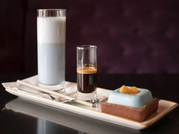 Mavi kibrit sütlü kahve, kahve espresso ve modern kremalı pasta. Zarif bir tatlı.