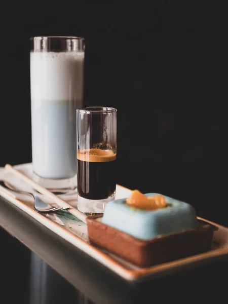 Espresso seti, mavi matcha latte ve modern kremalı pasta, seçici odaklanma. Zarif bir tatlı.