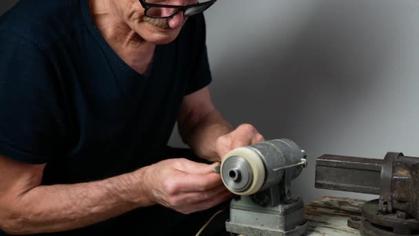 眼鏡をかけた老人は研削盤を使って道具を研いでいる 工芸品 職人技の概念 — ストック動画