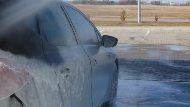 Man Spoelt Auto Met Spuitbus Tussen Waslaag Voertuig Schoonmaken Bij — Stockvideo