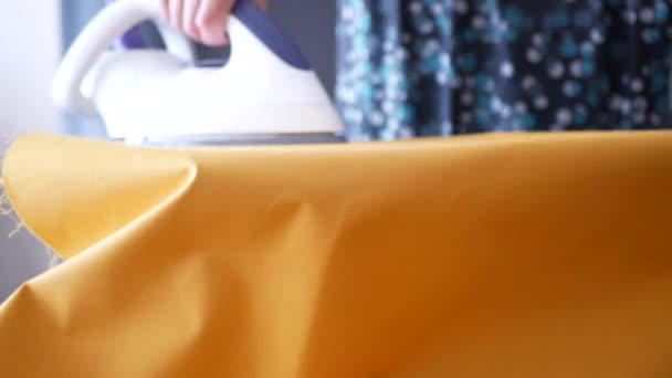 裁缝师在裁剪零配件前正在熨烫黄色的面料 蒸汽熨烫 — 图库视频影像
