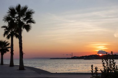 Sahilde güzel bir gün batımı karanlıkta birleşir. Öğleden sonra güneş ışığı altında İdyllik manzara