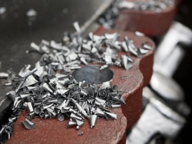Torna tezgahının yüzeyindeki metal talaşları, yakın çekim. Metal parçacıklarına dönüştü