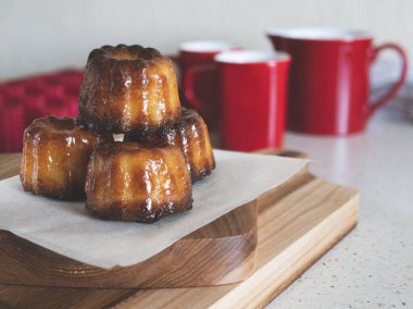 Bordeaux 'nun Caneles' i tahta bir tahtanın üzerinde. Ünlü Fransız hamur işi. Kahve ya da çay fincanı.