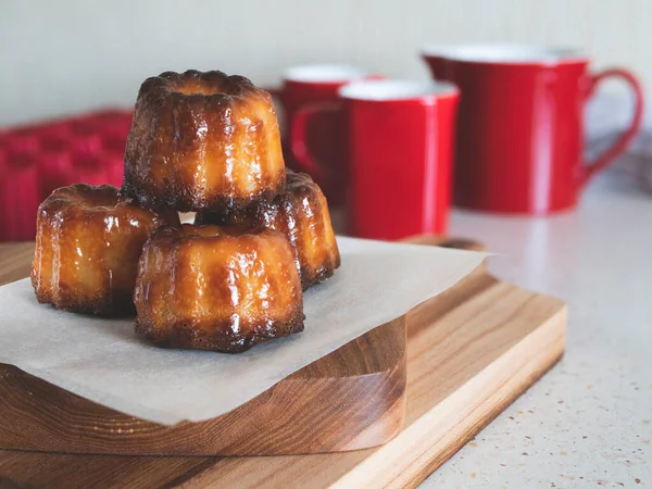 Bordeaux 'nun Caneles' i tahta bir tahtanın üzerinde. Ünlü Fransız hamur işi. Kahve ya da çay fincanı.