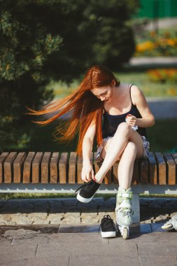 Tekerlekli paten bankta oturan kadın