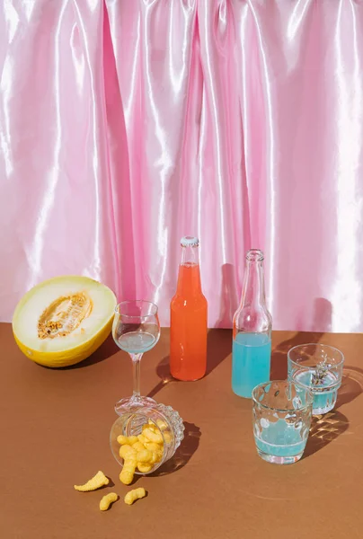 Summer , party scene with two bottles of cocktails, melons, glasses and snacks.Minimal Summer concept.