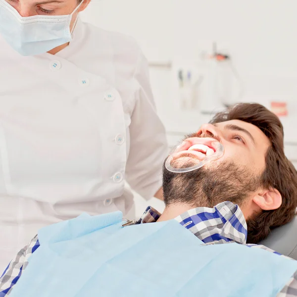 Jonge gelukkig man en vrouw in een tandheelkundige onderzoek op tandarts — Stockfoto