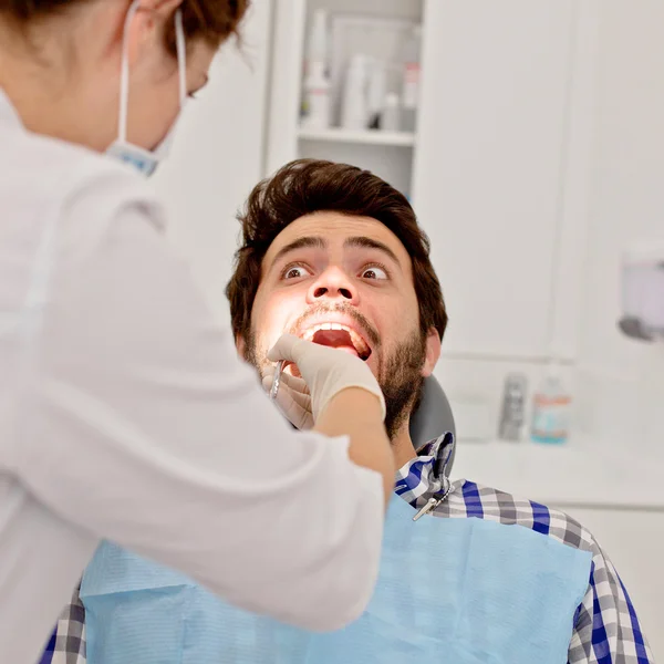 Jovem homem e mulher em um exame odontológico no dentista — Fotografia de Stock