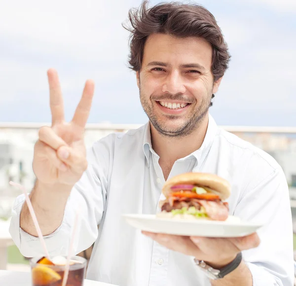 Jovem comendo um hambúrguer — Fotografia de Stock