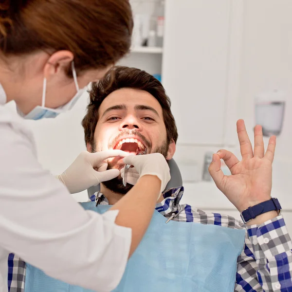 Jovem feliz homem e mulher em um exame odontológico no dentista — Fotografia de Stock