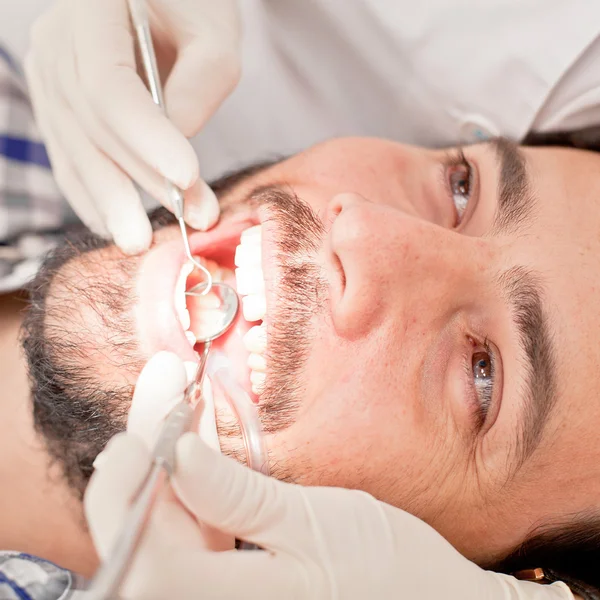 Jovem feliz homem e mulher em um exame odontológico no dentista — Fotografia de Stock