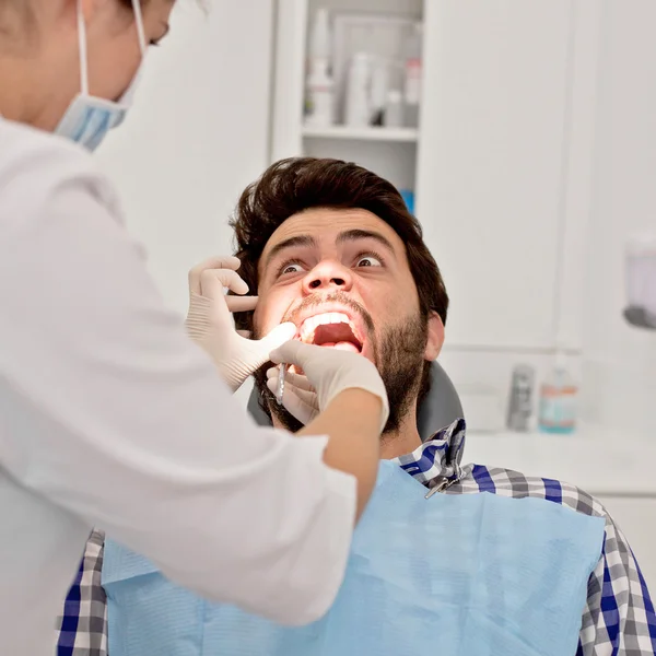 Jovem homem e mulher em um exame odontológico no dentista — Fotografia de Stock