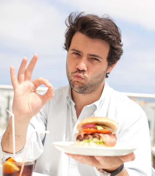 Jovem comendo um hambúrguer — Fotografia de Stock