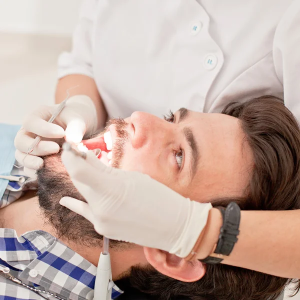 Jovem feliz homem e mulher em um exame odontológico no dentista — Fotografia de Stock