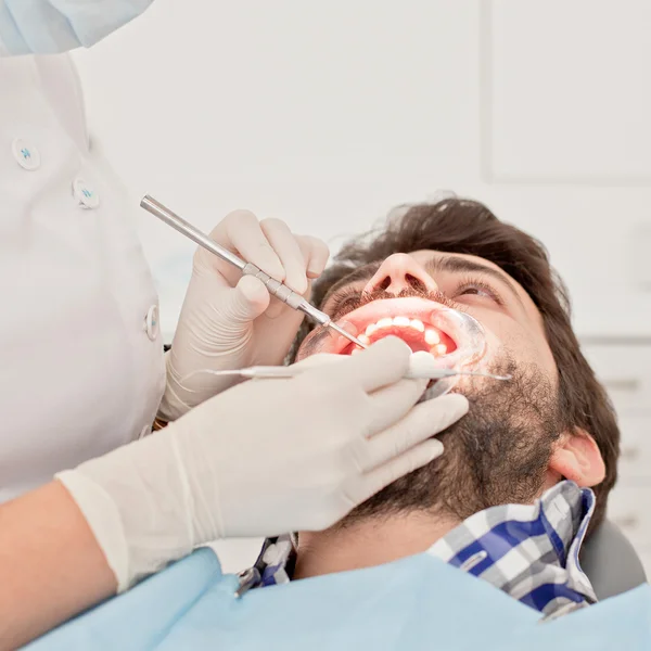 Joven feliz hombre y mujer en un examen dental en el dentista —  Fotos de Stock