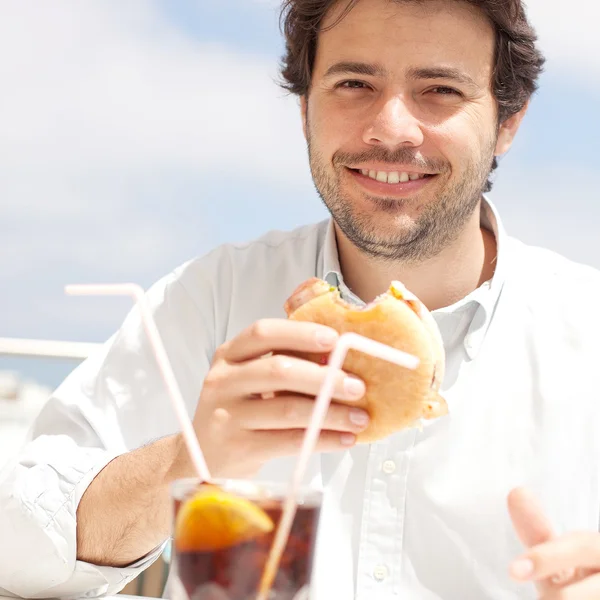 Jovem comendo um hambúrguer — Fotografia de Stock