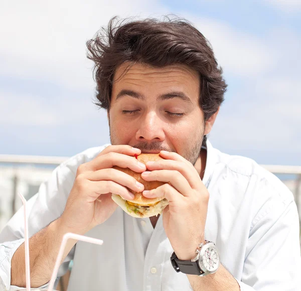 年轻人吃 hamburguer — 图库照片
