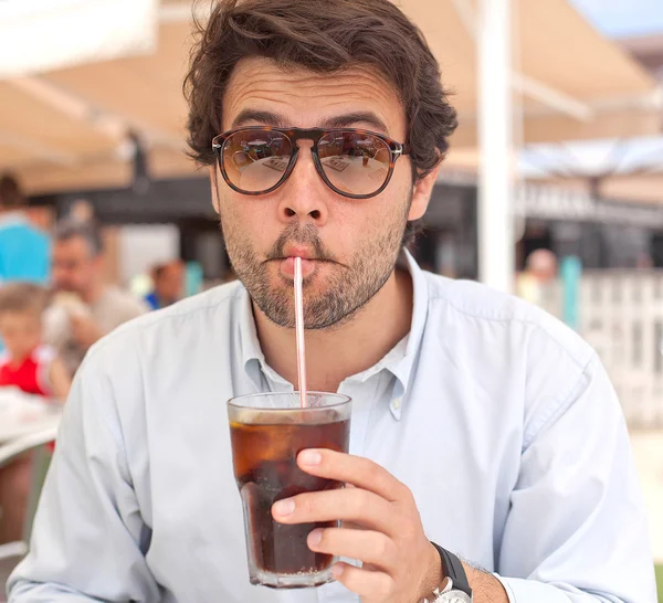 Young man drinking a beverage — Stock Photo, Image