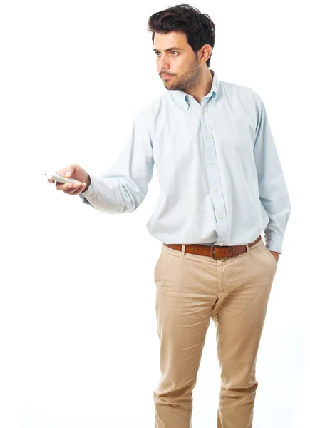 Молодий чоловік вказує з пультом дистанційного керування на білому тлі — стокове фото