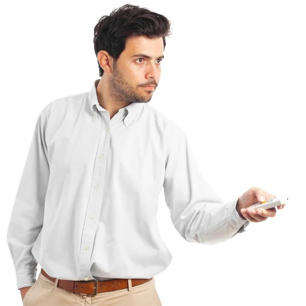 Young man pointing with a remote control on a white background — ストック写真