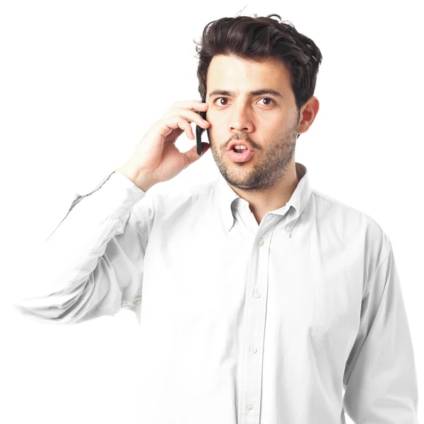 Молодой человек разговаривает по телефону на белом фоне — стоковое фото
