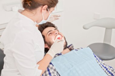 Genç mutlu erkek ve kadın diş hekimi, diş sınavında