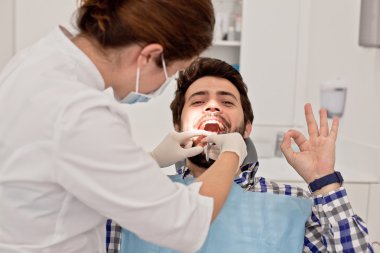 Genç mutlu erkek ve kadın diş hekimi, diş sınavında