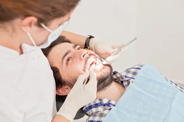 Genç mutlu erkek ve kadın diş hekimi, diş sınavında — Stok fotoğraf