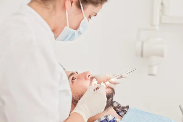 Jovem feliz homem e mulher em um exame odontológico no dentista — Fotografia de Stock