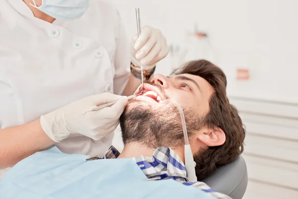 Jovem feliz homem e mulher em um exame odontológico no dentista — Fotografia de Stock