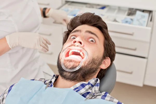 Jovem homem e mulher em um exame odontológico no dentista — Fotografia de Stock