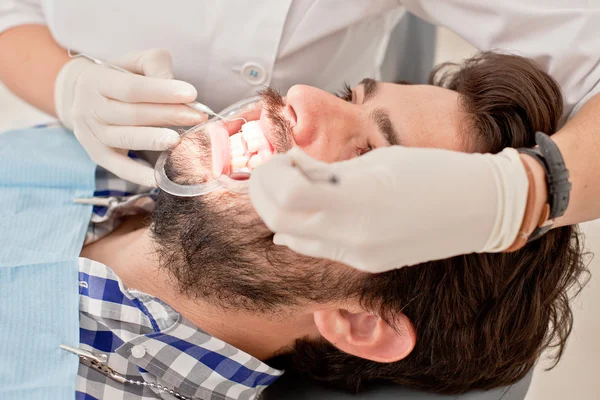 Jovem feliz homem e mulher em um exame odontológico no dentista — Fotografia de Stock