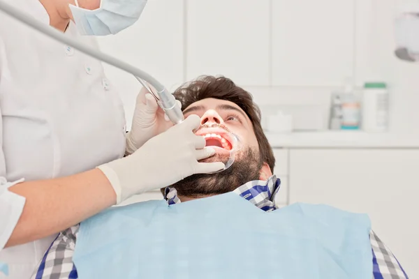 Jovem feliz homem e mulher em um exame odontológico no dentista — Fotografia de Stock