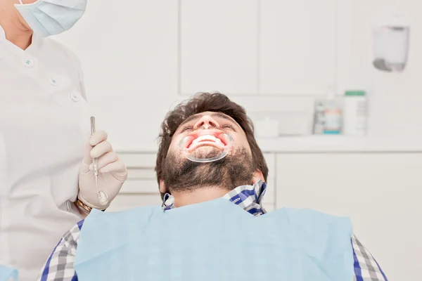 Jovem feliz homem e mulher em um exame odontológico no dentista — Fotografia de Stock