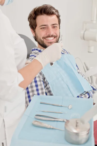 Joven feliz hombre y mujer en un examen dental en el dentista —  Fotos de Stock