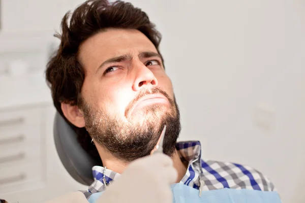 Joven hombre y mujer en un examen dental en el dentista —  Fotos de Stock