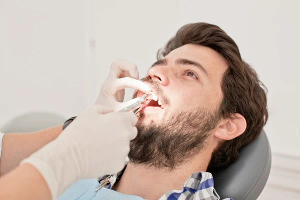 Joven feliz hombre y mujer en un examen dental en el dentista — Foto de Stock