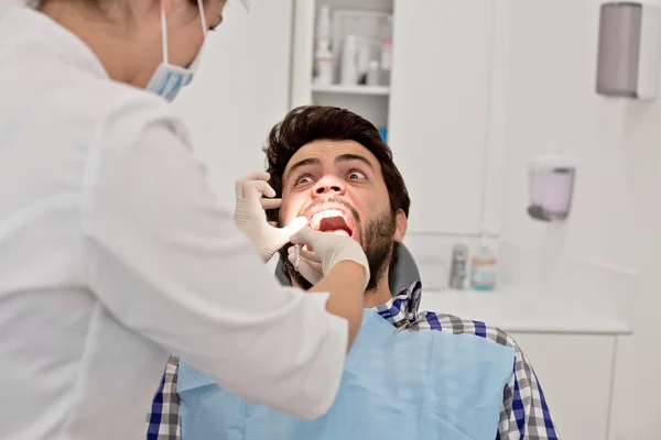 Jovem homem e mulher em um exame odontológico no dentista — Fotografia de Stock