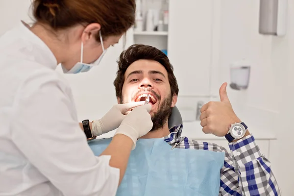 Jovem feliz homem e mulher em um exame odontológico no dentista — Fotografia de Stock