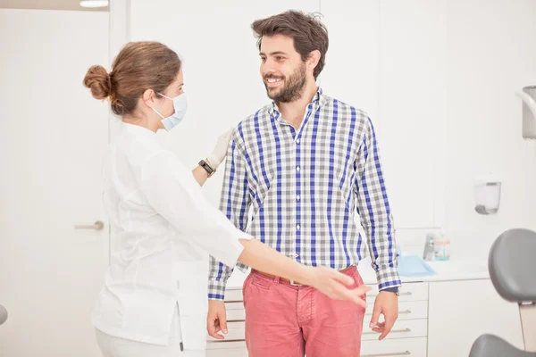 Jeune homme et femme heureux dans un examen dentaire chez le dentiste — Photo