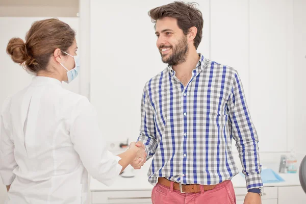 Jeune homme et femme heureux dans un examen dentaire chez le dentiste — Photo