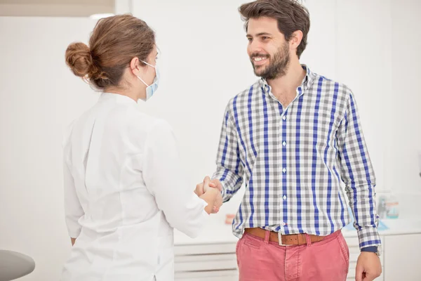 Jeune homme et femme heureux dans un examen dentaire chez le dentiste — Photo