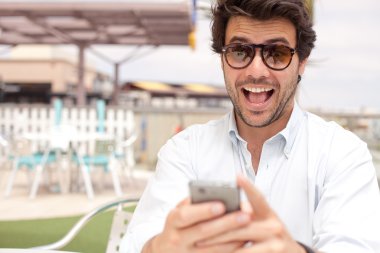 Mutlu genç adam bir cep telefonu kullanarak