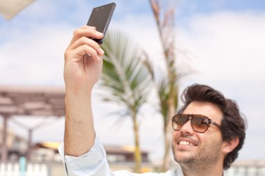genç adam onun cep telefonu ile fotoğraf çekme