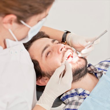 Genç mutlu erkek ve kadın diş hekimi, diş sınavında